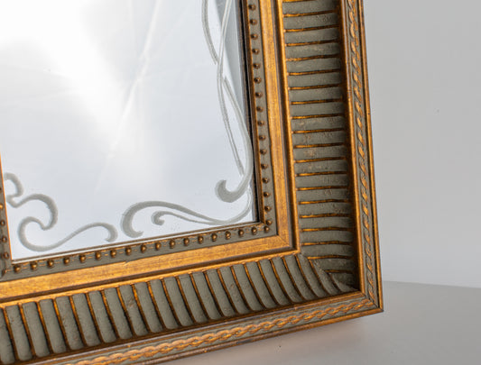 Dettaglio cornice scanalata oro e grigio e decoro sabbiato sul vetro